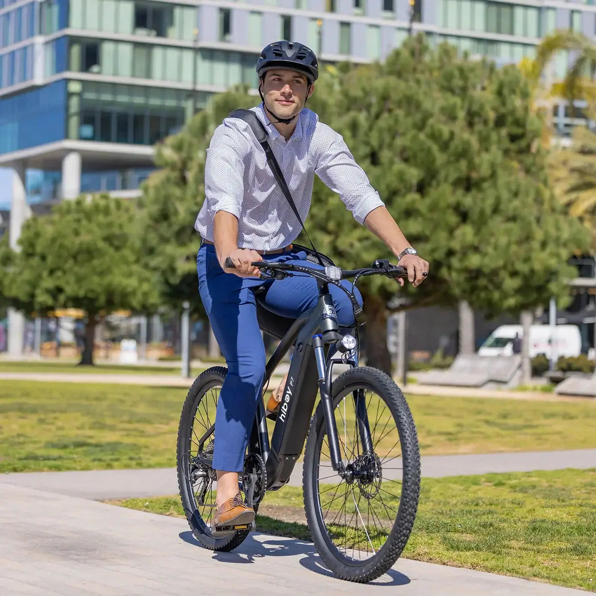 Man riding the Hiboy P7 E-Bike in a city park, showcasing its sleek design and urban style.