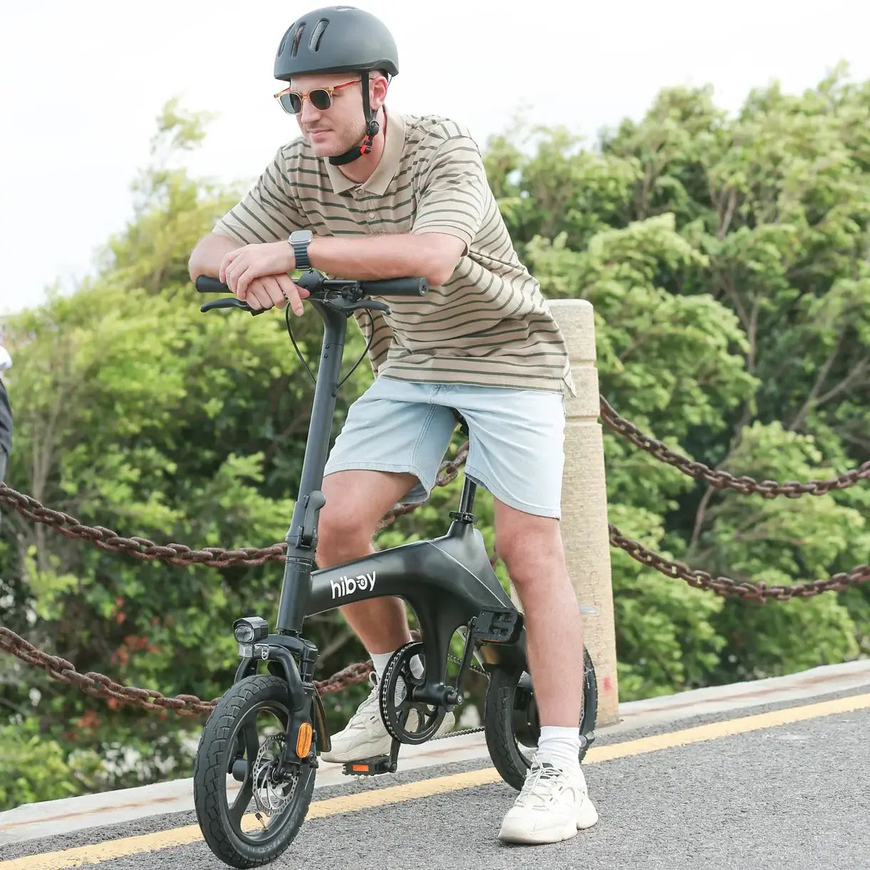 User riding Hiboy C1 Folding E-Bike in casual attire on a sunny day, showcasing its portability and style.