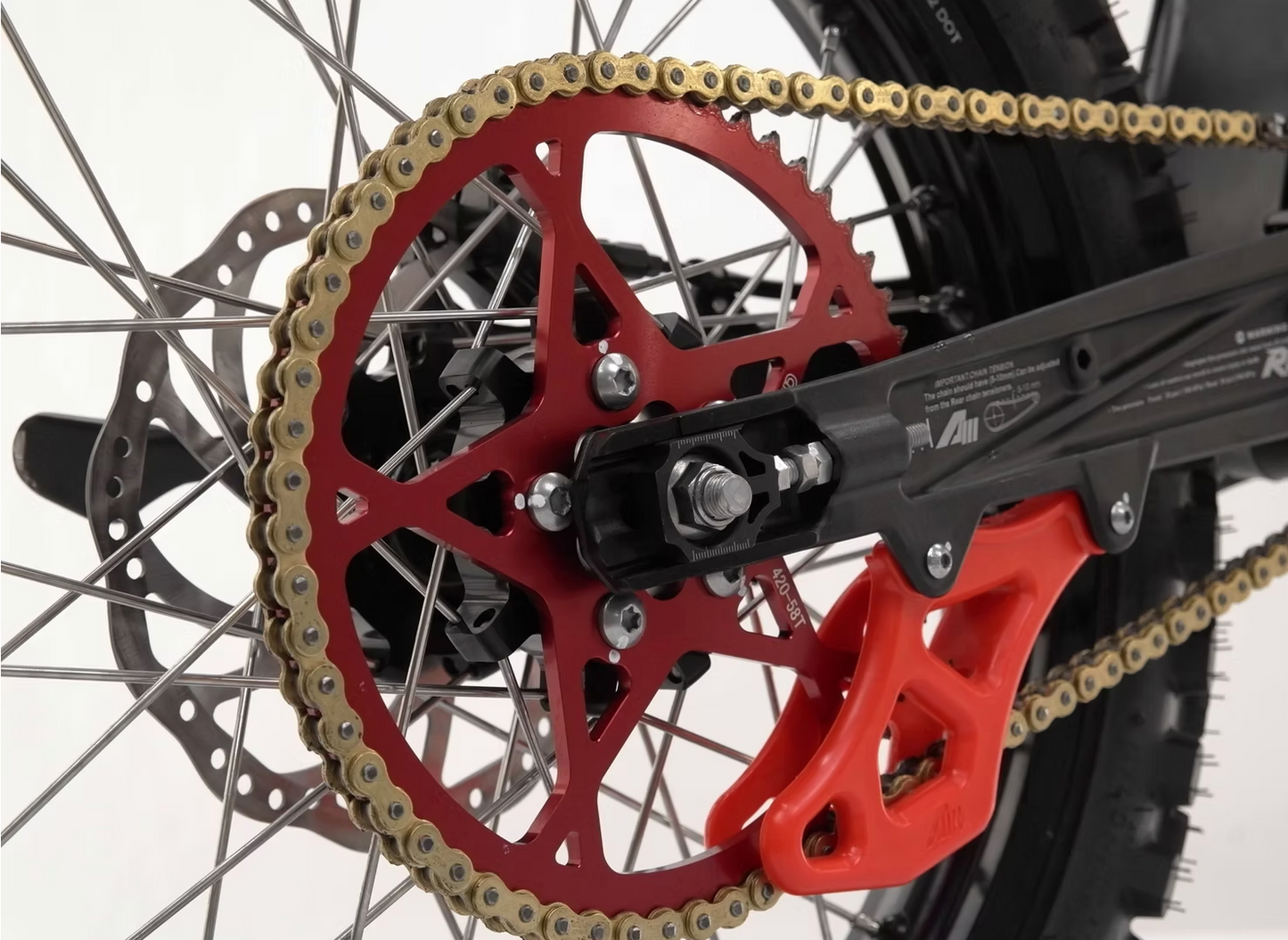 Close-up of the RFN Ares Rally E-Moto's vibrant red sprocket and chain, showcasing precision engineering.