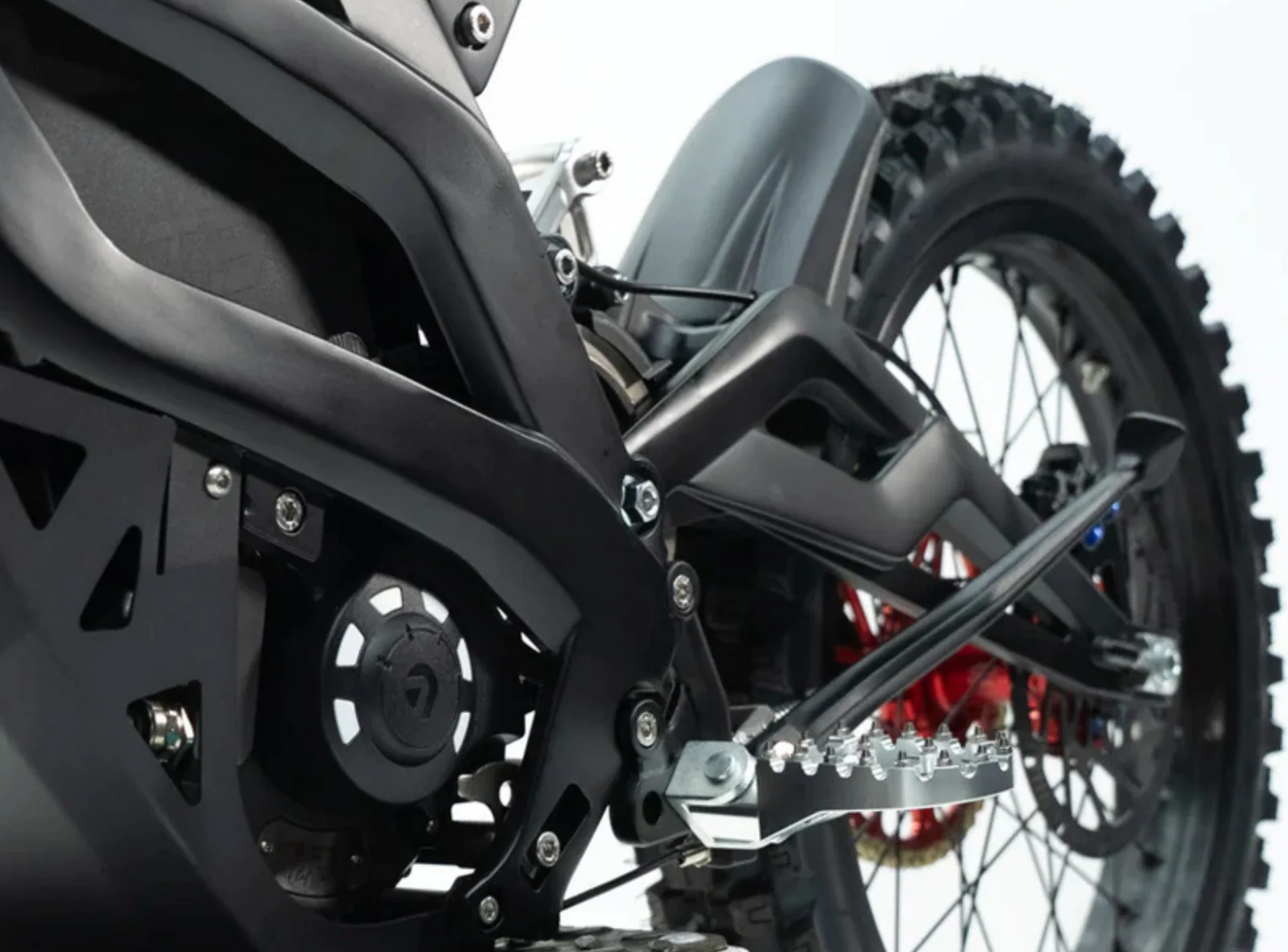 Close-up of Ventus V1+ electric dirt bike's advanced suspension and drivetrain components.