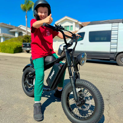 Child riding Freego M1 Mini electric bike smiling with thumbs up on sunny street.